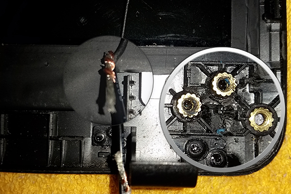 Detalle de reparación de bisagra y cable de WiFi cortado por el daño